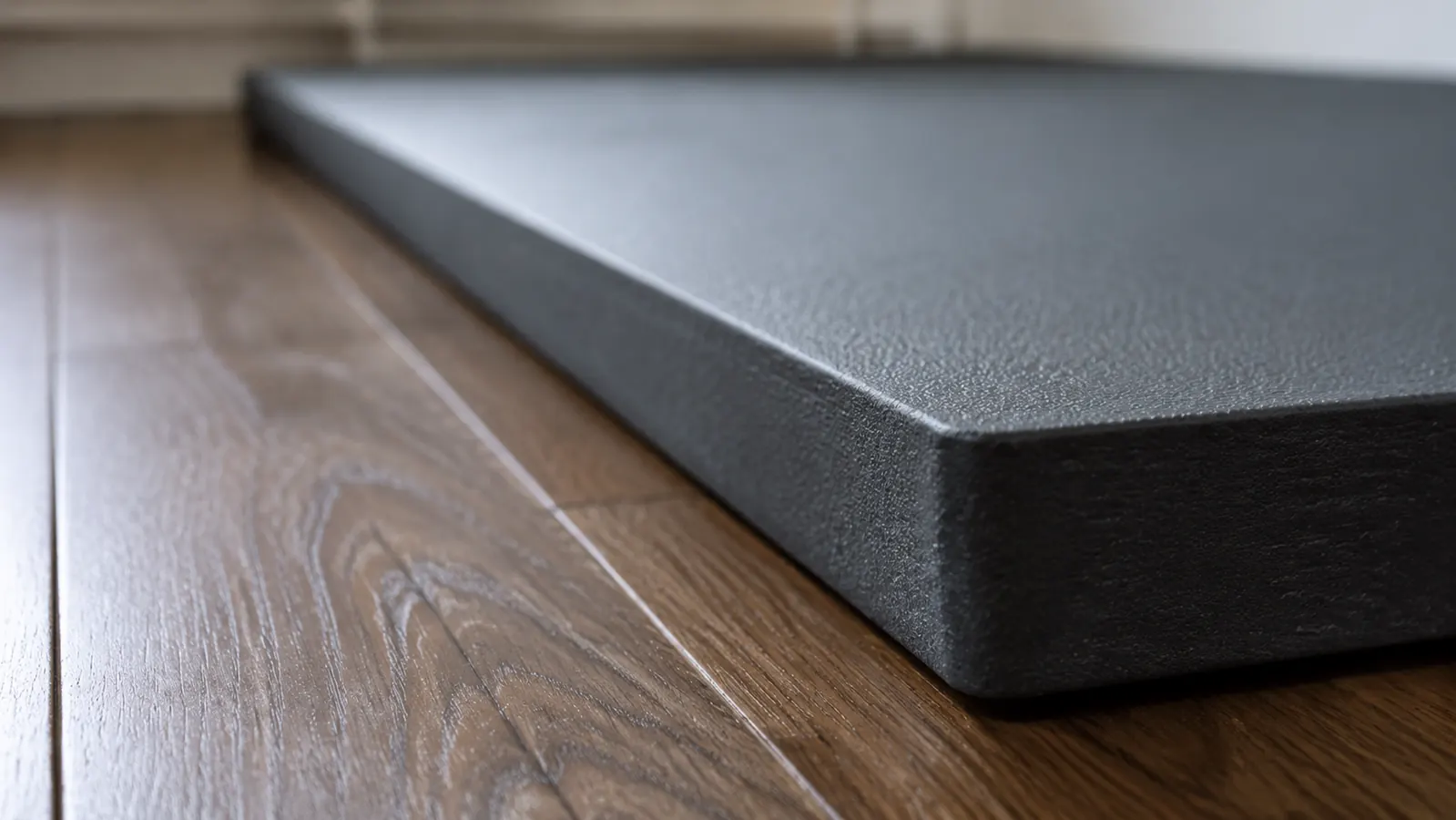 A close-up side view showing the thickness of an exercise mat on a hardwood floor